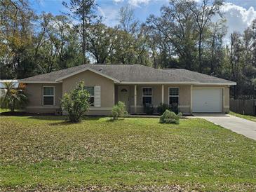 Charming single-story home featuring a well-maintained lawn, attached garage, and inviting entrance at 5520 Nw 57Th St, Ocala, FL 34482