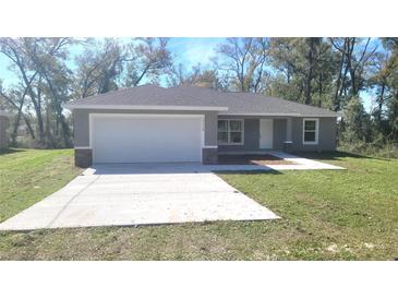 Charming single-story home with a two-car garage and a well-maintained lawn at 17718 Sw 112Th Ln, Dunnellon, FL 34432