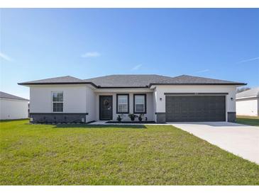 Charming single-story home with a well-maintained lawn and two car garage at 3352 Sw 127Th Lane Rd, Ocala, FL 34473