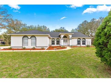 Charming single-story home featuring a white exterior, arched windows, and a well-maintained front yard with a landscaped pathway at 3621 Sw 52Nd Ter, Ocala, FL 34474