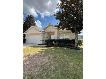 Charming single-story home with a well-manicured lawn and attached two-car garage at 4954 Sw 40Th Pl, Ocala, FL 34474