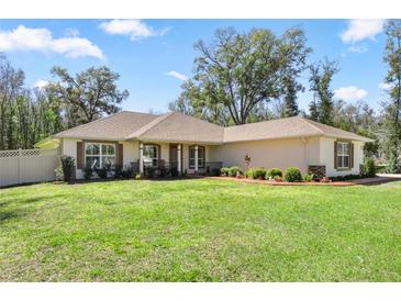 Inviting one-story home features a well-manicured lawn and charming curb appeal with shuttered windows at 530 Nw 113Th Cir, Ocala, FL 34482
