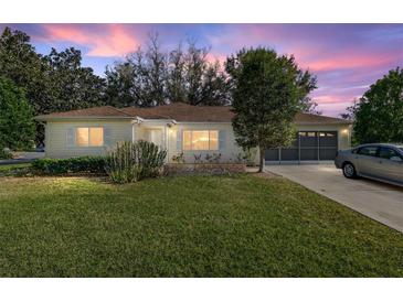 Charming single-story home featuring a well-manicured lawn, classic architectural details, and inviting curb appeal at 8740 Se 140Th Place Rd, Summerfield, FL 34491