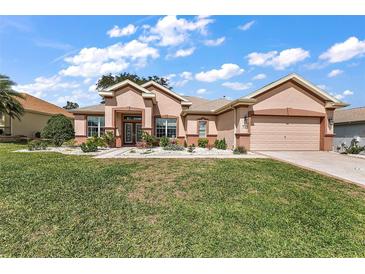 Charming single-story home with stucco exterior, well-manicured lawn, and mature landscaping at 12139 Se 91St Ter, Summerfield, FL 34491