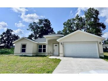 Charming single-story home featuring a two-car garage and well-maintained front yard at 3 Dogwood Drive Loop, Ocala, FL 34472