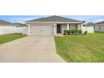 Charming single-story home features a two-car garage, manicured lawn, and front garden at 5537 Se 91St Pl, Ocala, FL 34480