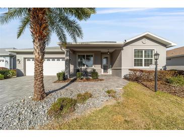 Charming home featuring a manicured lawn, paved walkway, and lovely landscaping with a palm tree at 9974 Sw 88Th Loop, Ocala, FL 34481
