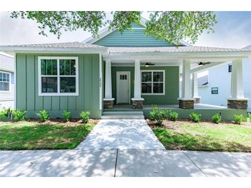 Charming green home with a welcoming front porch and manicured landscaping at 2735 Se 19Th Ct, Ocala, FL 34471