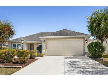 Charming single-story home with a well-manicured lawn and a two-car garage at 3407 Melbourne Ln, The Villages, FL 32163