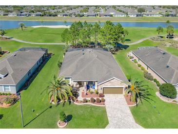 Stunning aerial view of a beautiful home overlooking a golf course and scenic pond at 7527 Sw 97Th Terrace Rd, Ocala, FL 34481