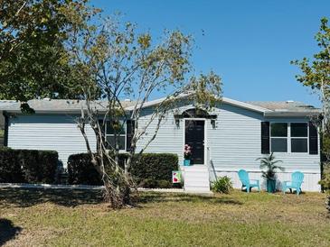 Charming single-story home with light blue siding and a well-manicured front yard at 8106 County Road 109, Lady Lake, FL 32159