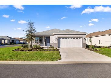 Charming single-story home with well-manicured lawn and a two-car garage on a sunny day at 8802 Sw 79Th Loop, Ocala, FL 34481
