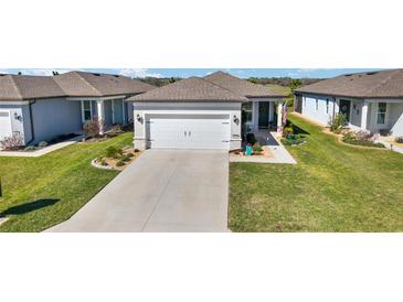 Charming single-story home with a well-manicured lawn and a two-car garage on a sunny day at 9381 Sw 52Nd Loop, Ocala, FL 34481