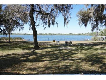 Scenic lake view with mossy trees and a bench for enjoying the tranquil scenery at 1764 Se 169Th Avenue Rd, Silver Springs, FL 34488