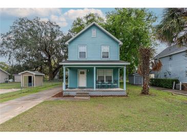 Charming two-story home with a light blue exterior, inviting front porch, and well-manicured lawn at 307 Nw 10Th Ave, Ocala, FL 34475