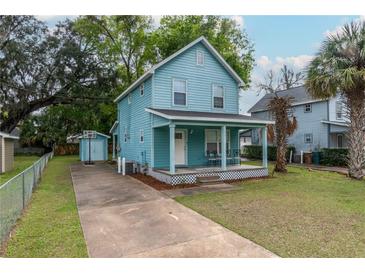 View of the side of the home showing its light blue exterior, shed, and basketball hoop at 307 Nw 10Th Ave, Ocala, FL 34475