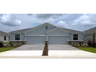 Charming duplex featuring stone accents, well-manicured landscaping, and a spacious driveway at 4749 Nw 39Th Street Rd, Ocala, FL 34482