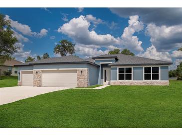Beautiful single Gathering home featuring a stone accent, well maintained lawn, and neutral blue paint at 9975 Sw 39Th Ter, Ocala, FL 34476