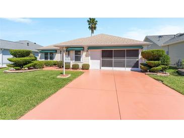 Charming single-story home features a well-manicured lawn and a painted driveway at 1913 Augustine Dr, The Villages, FL 32159