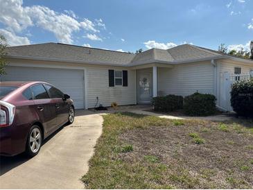 Charming single-story home featuring an attached garage and well-maintained landscaping in a tranquil neighborhood at 17760 Se 91St Freedom Ct, The Villages, FL 32162