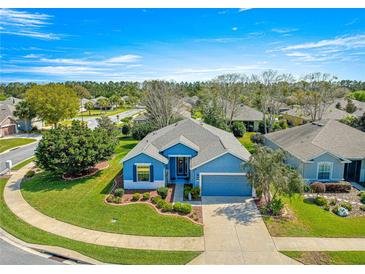 Beautiful single-story home featuring a well-manicured lawn, two-car garage, and attractive blue exterior at 9230 Sw 66Th Loop, Ocala, FL 34481