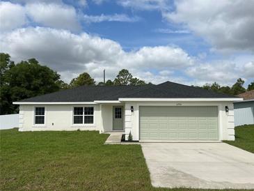 Charming single-story home with a fresh exterior, a well-manicured lawn, and an attached two-car garage at 2750 Sw 151St Ave, Ocala, FL 34481