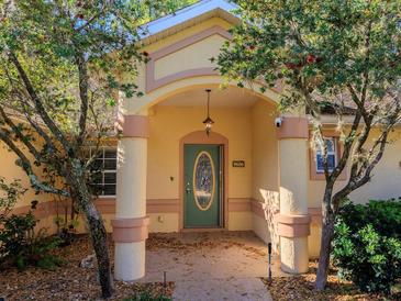 Inviting front entrance with pillars, a decorative door, and the house number displayed above at 9606 Sw 53Rd Cir, Ocala, FL 34476