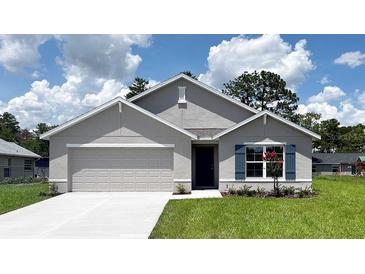 Charming single-story home featuring a two-car garage, manicured lawn, and elegant blue shutters at 16805 Sw 50Th Cir, Ocala, FL 34473