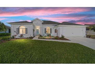 Charming single-story home with manicured lawn and inviting front yard seating area at 2380 Nw 55Th Avenue Rd, Ocala, FL 34482