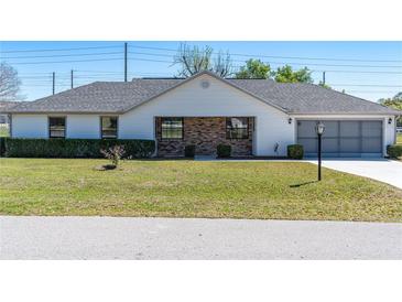 Charming single-story home with a well-maintained lawn and attached two-car garage at 3275 Nw 44Th Ct, Ocala, FL 34482