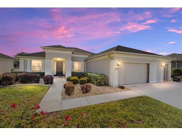 Charming one-story home with well-manicured landscaping and a two-car garage during a colorful sunset at 7283 Sw 94Th Ave, Ocala, FL 34481