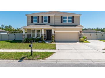 Two-story home featuring a two-car garage, covered front porch, neutral color palette and well-maintained landscaping at 1861 Ne 50Th Ter, Ocala, FL 34470