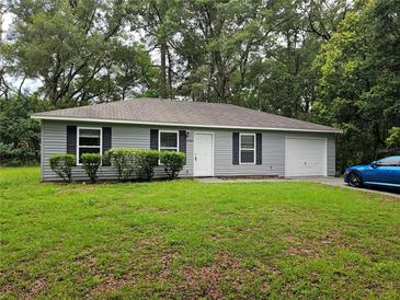 Charming single-story home with a well-manicured front yard and attached garage at 20992 Sw Marine Blvd, Dunnellon, FL 34431