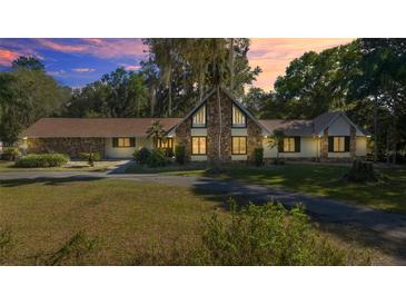 Charming single-story home featuring a unique stone facade and a well-manicured front lawn with mature trees at 2130 Sw 37Th Street Rd, Ocala, FL 34471