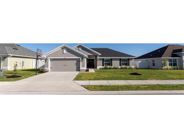 Charming single-story home features a two-car garage and a well-maintained lawn, enhancing its curb appeal at 5001 Sw 91St Pl, Ocala, FL 34476