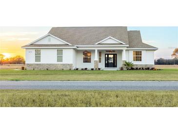 Charming single-Gathering home showcasing manicured lawn, covered entry, and decorative columns at 8214 Nw 17Th Cir, Ocala, FL 34475