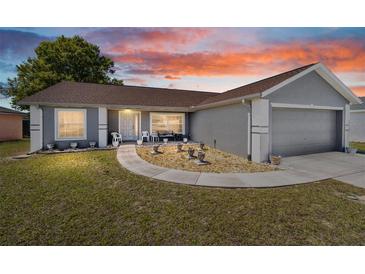 Inviting home exterior with manicured landscaping, walkway, and a two-car garage at 8216 Sw 60Th Ter, Ocala, FL 34476