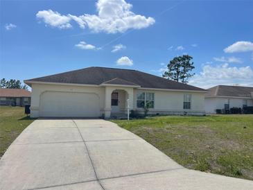 Inviting single-story home with a classic design, tidy lawn, and an attached garage for convenience at 8386 Sw 136Th Pl, Ocala, FL 34473