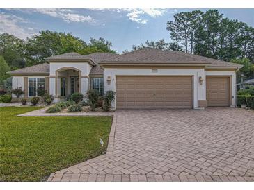 Charming single-story home with a three-car garage and well-manicured front lawn at 9509 Se 124Th Loop, Summerfield, FL 34491