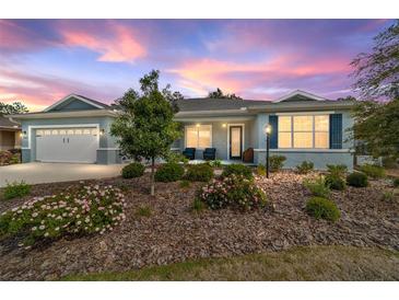 Charming single-story home featuring a three-car garage, covered porch, and landscaped front yard at 10445 Sw 90Th Street Rd, Ocala, FL 34481