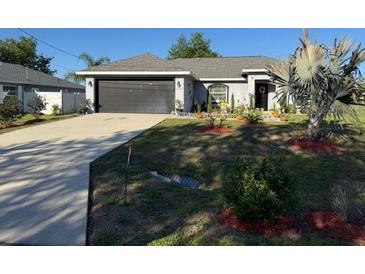 Charming single-story home with a well-manicured lawn and a spacious two-car garage at 137 Juniper Loop, Ocala, FL 34480