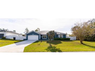 Charming single-story home featuring a well-manicured lawn and a two car attached garage at 16201 Sw 47Th Ter, Ocala, FL 34473