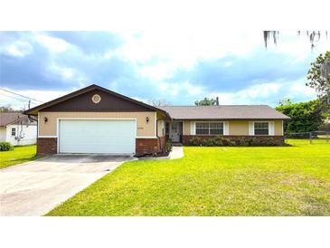 Charming single-story home features a two-car garage, brick accents and a well-manicured lawn at 2146 Ne 10Th St, Ocala, FL 34470