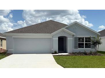 Charming single-story home with a two-car garage, gray exterior, and well-manicured lawn at 4754 Sw 88Th Ln, Ocala, FL 34476