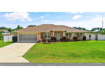 Charming single-story home with a well-manicured lawn and a two-car garage at 6890 Sw 128Th Pl, Ocala, FL 34473