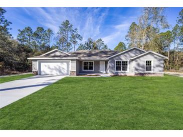 Charming single-story home with a well-manicured lawn, attached two-car garage, and beautiful stone accents at 7798 Sw 134Th Ave, Dunnellon, FL 34432