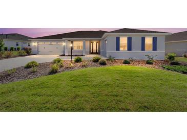 Charming single-story home featuring a manicured lawn, symmetrical landscaping and a two car garage at 8218 Sw 92Nd Cir, Ocala, FL 34481