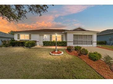 Charming home featuring a well-manicured lawn, tidy landscaping, and an inviting facade at 9741 Sw 97Th Ln, Ocala, FL 34481