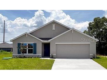 Charming single-Gathering home with a two car garage, blue shutters, and a well-manicured lawn at 242 Marion Oaks Crse, Ocala, FL 34473