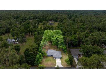 Expansive aerial view shows property, surrounded by lush greenery and mature trees, offering privacy at 5118 Sw 197Th Ter, Dunnellon, FL 34431